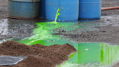 green chemical spilling from oil tanks