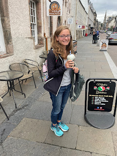 Me smiling and holding a milkshake in Inverness.