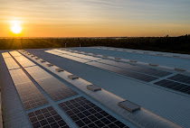 A row of solar panels installed on the roof of a house against the backdrop of a sunset in Africa. Solar panels convert sunlight into electricity that can be used to power a home or sold to the grid. Solar energy is a clean and renewable energy source that can help reduce Africa's dependence on fossil fuels.