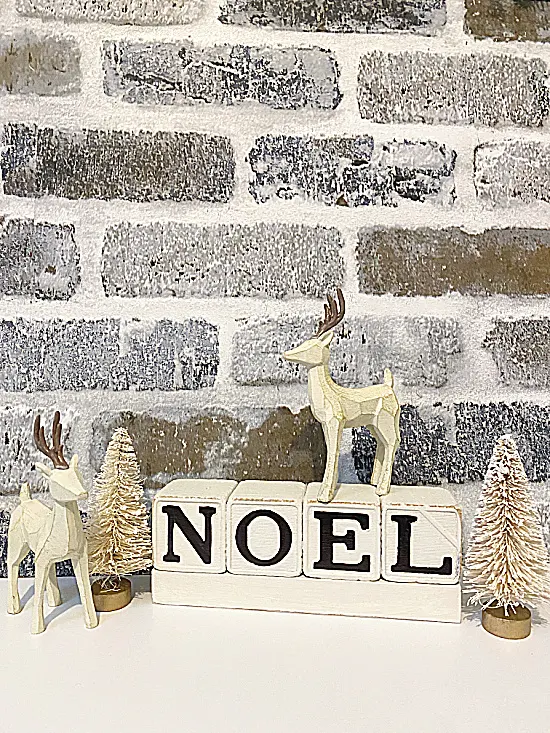 brick wall and noel sign with trees and reindeer