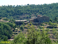 El mas de Postius, a l'altra banda de la riera del mateix nom, vist des del Pla del Simon