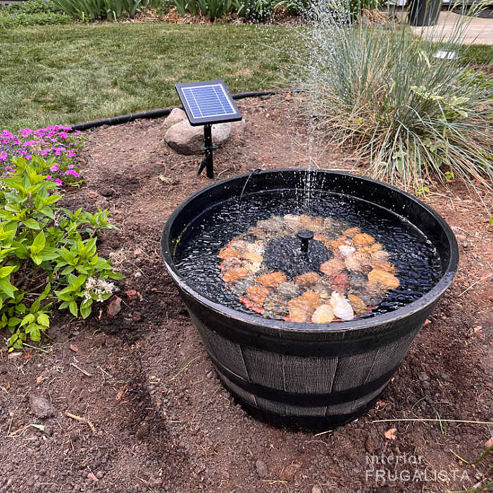 Rechargeable solar fountain with decorative river rocks.