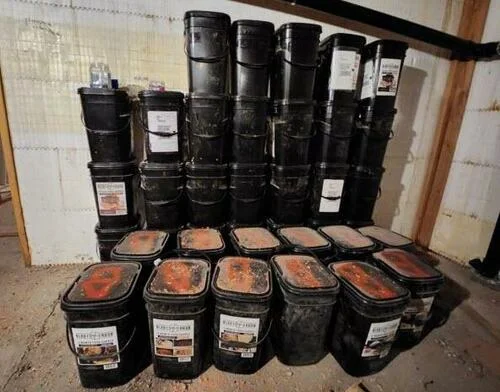 Buckets of long-term survival food are stacked against the basement wall at Fortitude Ranch Nevada on March 2, 2023.