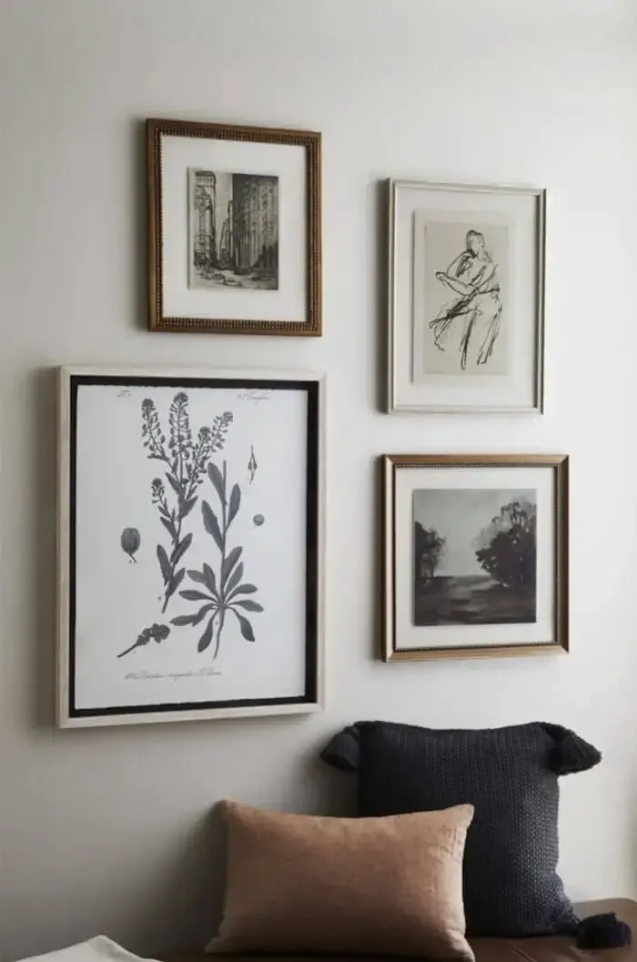 Four framed prints hanging on beige wall