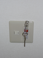【照片：電燈開關。把鑰匙棒插進去就會打開電燈的電源了。】