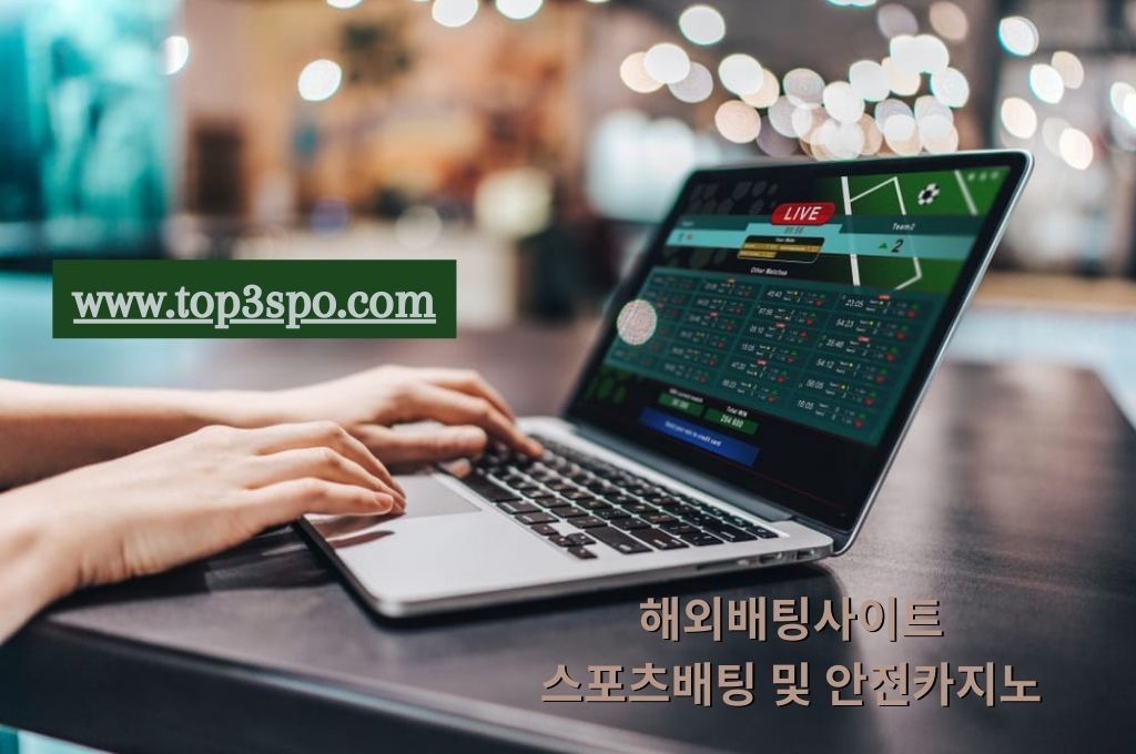 Bettor's hand pointing on his laptop keyboard playing online sports betting