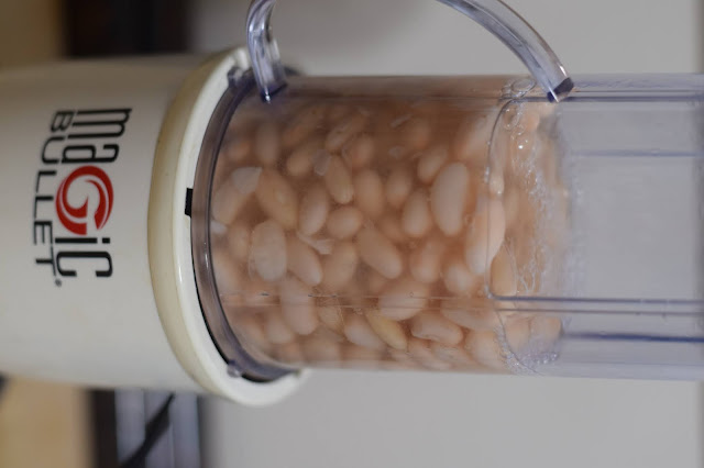 White beans being blended in a blender.