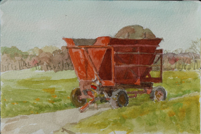 Watercolor sketch of an orange metal wagon in warm sunlight. The wagon consists of a chassis with four rubber-tired wheels, a frame, and a wedge-shaped hopper. Green fields and trees in background.