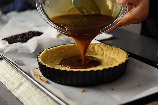 Pour the pecan pie filling into the baked pie crust.