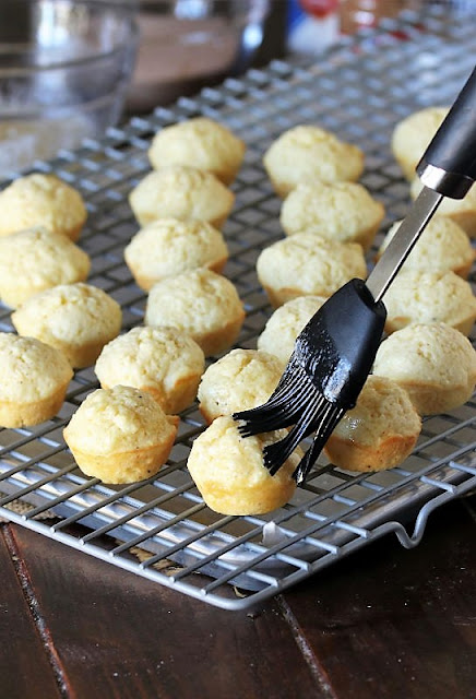 Brushing Baked Cinnamon Sugar Donut Hole Muffins with Melted Butter Image