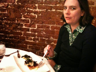 A woman in her thirties eats dinner at a restaurant in New Orleans.
