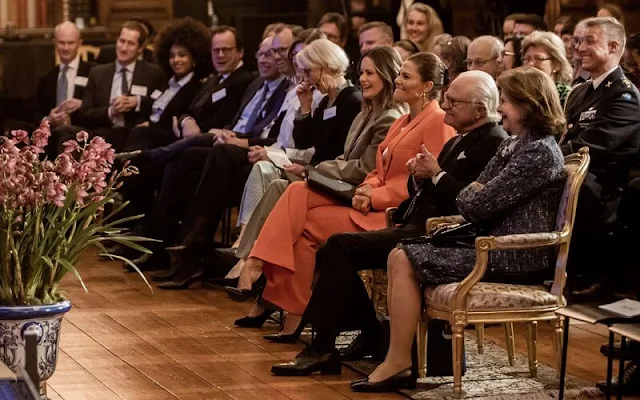 Crown Princess Victoria in Zara shawl lapel orange blazer suit. Princess Sofia in Tiger of Sweden Nicee blazer and Irez trouser