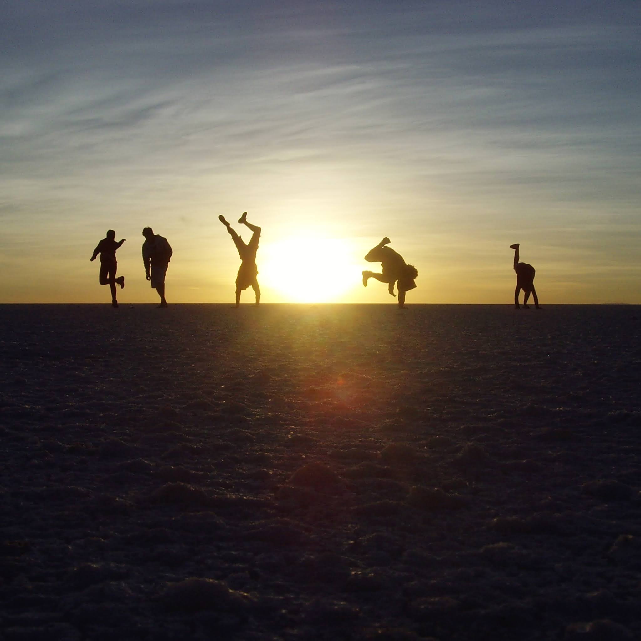 five people on the salt flat at sunrise in bolivia