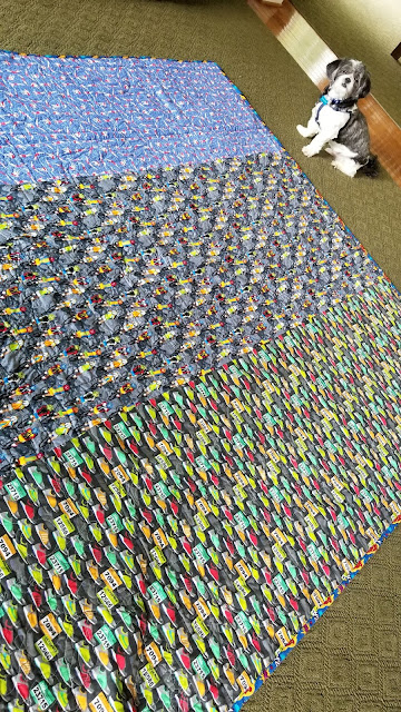 The back of the quilt with the binding. There's also a dog near the quilt. 