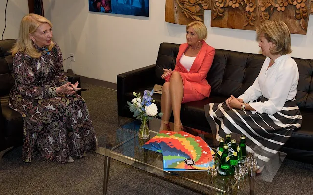 Queen Mathilde wore an orange silk dress, jumpsuit by Natan, and a stripe skirt and white silk blouse by Natan