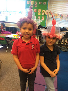 A couple of young girls posing with their balloon princess crowns