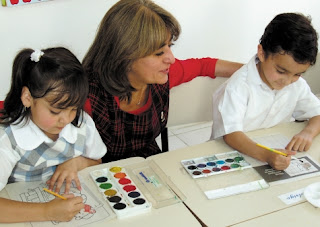 NAMC encouraging quiet in the montessori environment teacher with painting students