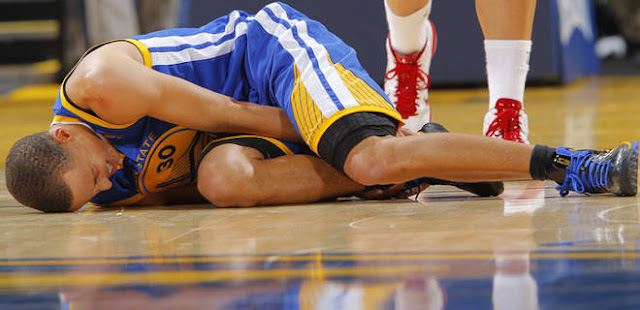 Stephen Curry au sol après une blessure lors d'un match NBA