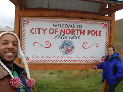 mom and I standing in front of "welcome to north pole" sign