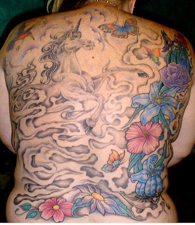 Mythical back piece tattoo with unicorn and flowers.