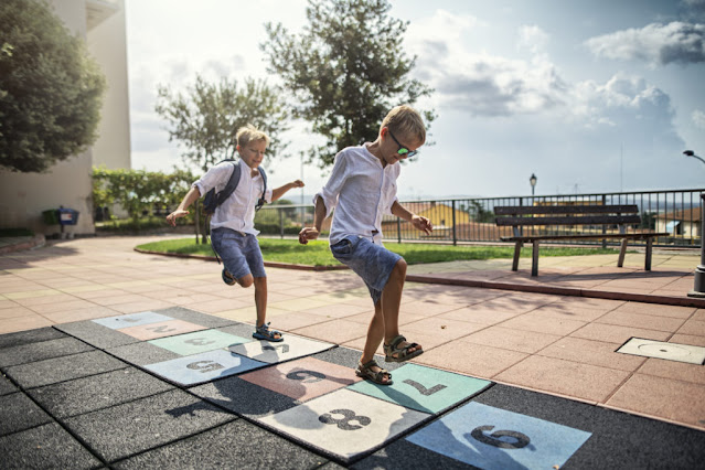 enfants jouant sur une marelle de rue