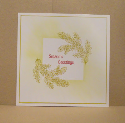 Christmas card, foliage branches and seasons greetings sentiment