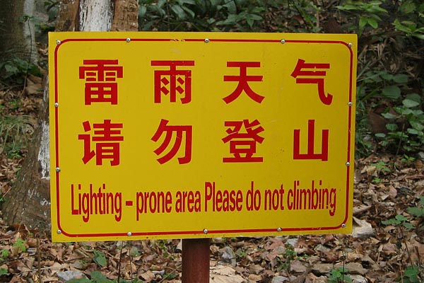 a sign with Chinese characters and then "Lighting prone area Please do not climbing"