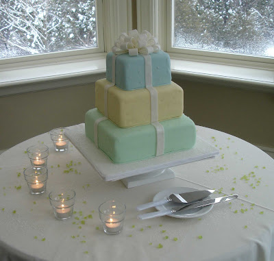 A small wedding cake with handmade gumpaste flowers leaves and pearls