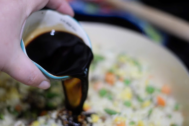 Soy sauce being added to the pork fried rice. 