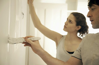 A couple painting their wall