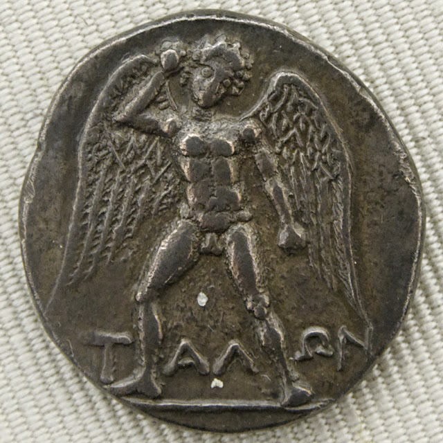 Изображение гигантского бога Талоса, вооруженного камнем, на лицевой стороне серебряной дидрахмы из Феста на Крите, датируемой примерно 300–270 годами до нашей эры.