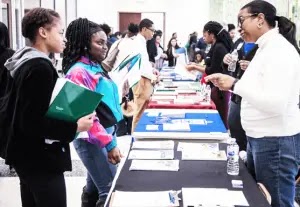 Woman speaking to two young people about Effective Event Promotion