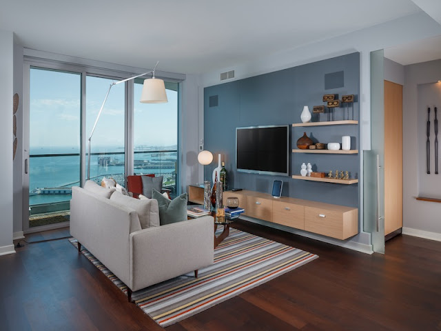 Picture of small contemporary living room with white sofa and large tv on the blue wall