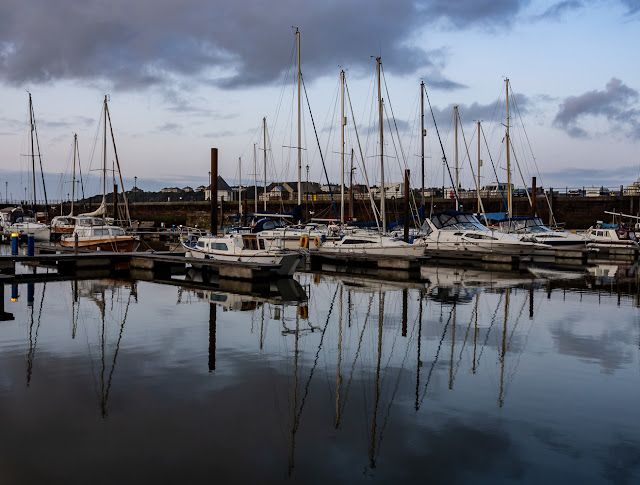 Photo of reflections on the still water at Maryport Marina