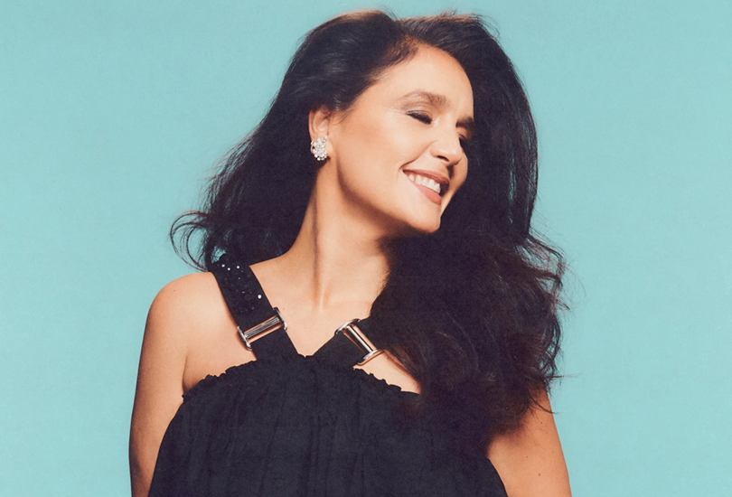 A shot from the photoshoot for Jessie Ware’s fifth studio album ‘That! Feels Good!’. Featuring Jessie in a black strap dress, looking away from the camera with a smile.