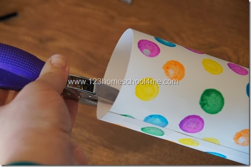 us a hole punch to make two holes across from each other on one end of cylinder