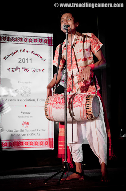 Huchori Performance by an Assamese group of boys @ Rongali Bihu Festival, IGNCA, Delhi : Posted by VJ SHARMA on www.travellingcamera.com : Huchori - Huchori is an integral part of Rongali Bihu. Choral parties of singers and dancers moving from house to house is a salient feature of Rongali Bihu !!!Huchori is a regular thing which happens during the Rongali Bihu and it is a custom of community singing in which a group of singers visit each home in their locality and sing songs containing spiritual and moral values. The group comprises only of men and the event coincides with the Assamese New Year. The group visits every house irrespective of caste, creed and social status of the householder. During the reign of the Ahom dynasty, Huchori singing was a usual custom in the royal palaces. At a later period it began to be practiced by common people.A group of boys performed Hichuri on the stage and it was really interesting to see overall getup of folks in the groups and it seems elder folks also join this group to better guide the younger ones :) .. Although I was not able to make any sense out of the songs or dialogs, but it looked very interesting !!!Huchori group begins its procession from the village headman’s house and continue towards the other houses in the vicinity. The procession proceeds amidst chanting, singing and dancing. Visiting each house in the village, the group accepts some donation from the residents. The singers usually carry a staff, a bag, an umbrella and a lamp while roaming around the village. Their instruments comprise of dhol (drum), taal (cymbals), pepa (horn pipe) and taka (bamboo clapper).This seems more like Lohri in North India.. Specially in Punjab and Himachal Pradesh !!! On Lohri week, boys make some groups and start visiting various houses in the village/town and sing different Lohri Songs... After that every house master offer some stuff like wheat, corns or rice.. and now people prefer to give money.. as it's convenient for both parties :)Huchori Performance at Rongali Bihu Festival in Indira Gandhi National Center of Arts was amazing and the energy level of folks performing was commendable !!!Here is one of the most enthusiatic performer of Hichori Dance who was handling dhol during Riganli Bihu in Delhi !!!Notice the dressed of all these folks and they have taken proper care of clothings they should use !!!Although I was not able to make out anything as they were singing in Assamese but their expressions were telling a story !! Here a couple is presenting something for god and praying for good !This whole event was organized by Assam association Delhi in partnership with Indira gandhi National Center of Art and it was wonderful experience at Rongali bihu festival !!!