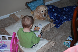 toddler spending time with dog, reading books