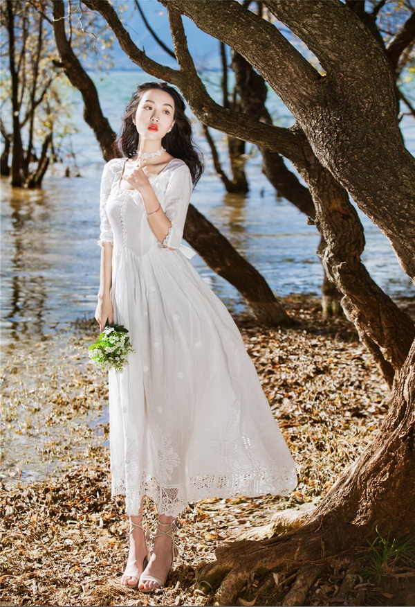 Thiếu nữ áo đầm trắng cầm hoa