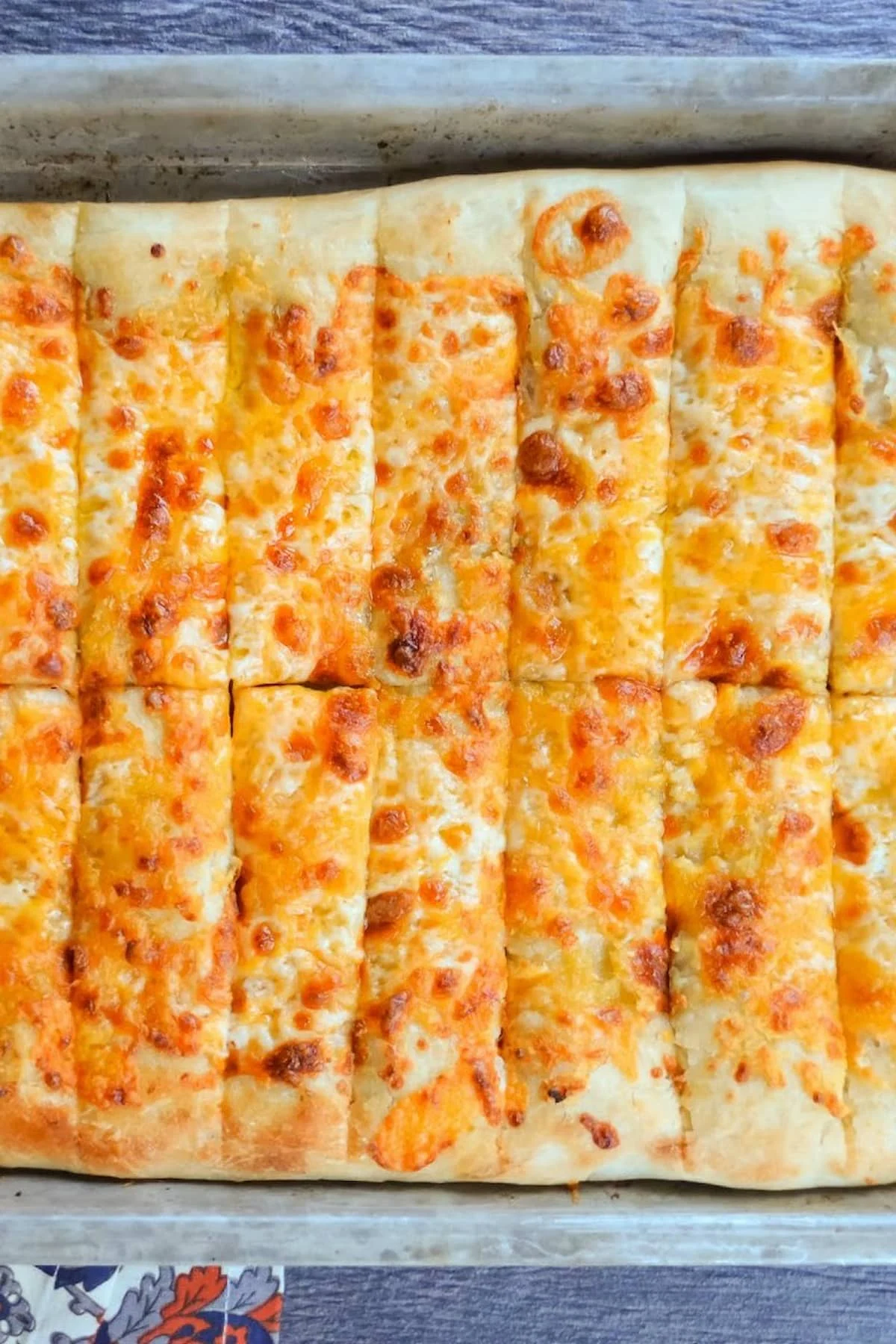 A down shot of a pan of Pizzeria Style Cheesy Breadsticks.