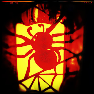 Spider outline on an orange lantern, looks cute and spooky