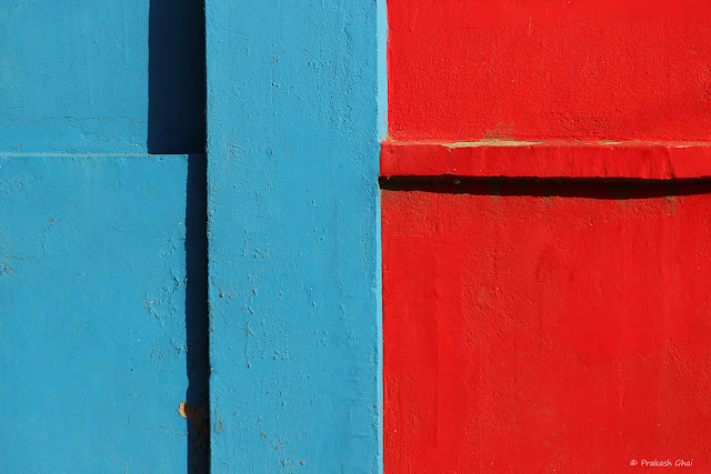 A Minimalist Photograph of a Wall with Two primary colors, blue and red.