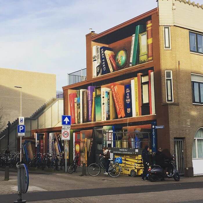 Dutch Artists Paint An Enormous Bookcase On An Apartment Building That Features Residents’ Favorite Books