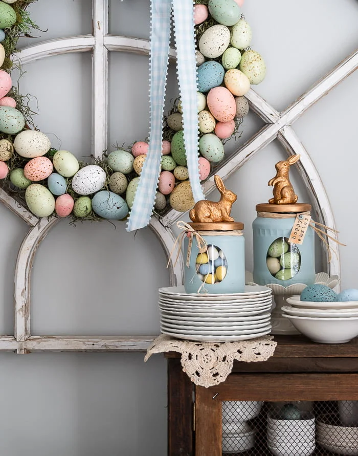 pastel egg wreath, blue bunny jars filled with treats, doily, ironstone stack