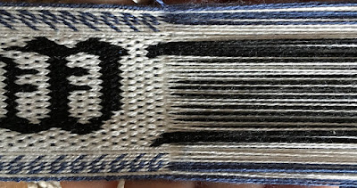 A photo of a section of tablet woven band with the weft removed and the twist between the tablets and the band removed