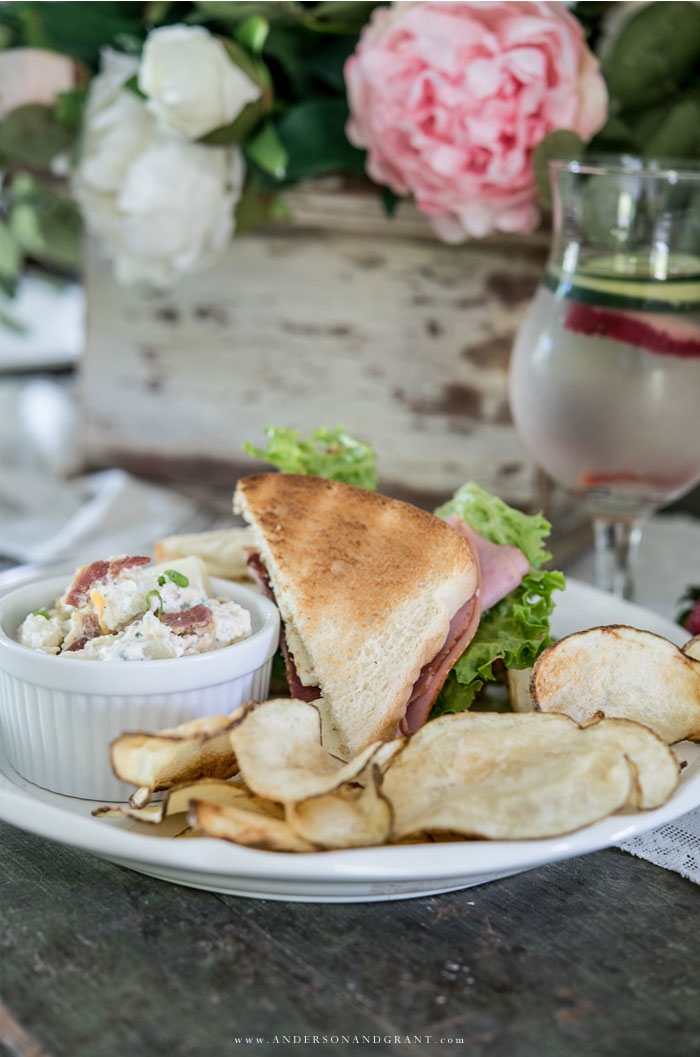 Plate with sandwich, potato salad, and potato chips.