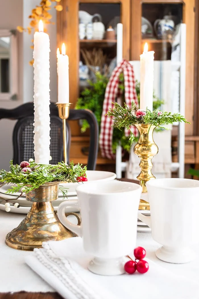 white ironstone, brass candlesticks, cedar candle rings with red frosted cranberries