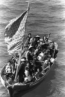 35 Vietnamese refugees wait to be taken aboard the amphibious command ship USS BLUE RIDGE (LCC-19). They are being rescued from a 35 foot fishing boat 350 miles northeast of Cam Ranh Bay, Vietnam, after spending eight days at sea—PH2 Phil Eggman