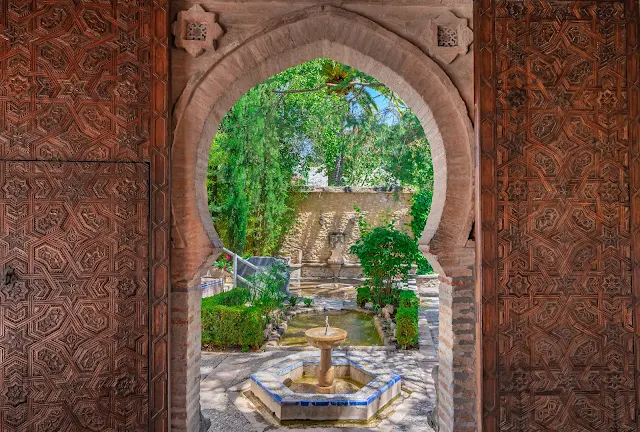Puerta árabe que da paso a un luminoso jardín oriental.