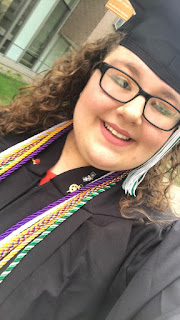 monica wearing glasses and her graduation clothing, photo is a selfie